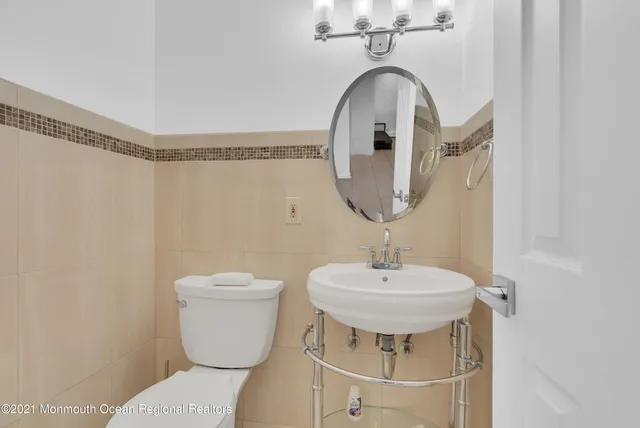 a bathroom with a sink a toilet and a mirror