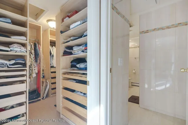 a view of walk in closet with clothes and shoes