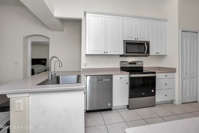 a kitchen with stainless steel appliances a refrigerator sink and microwave