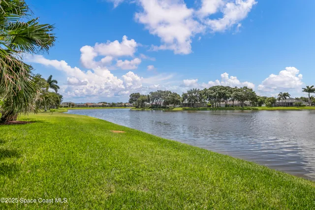 an aerial view of residential houses with outdoor space and lake view