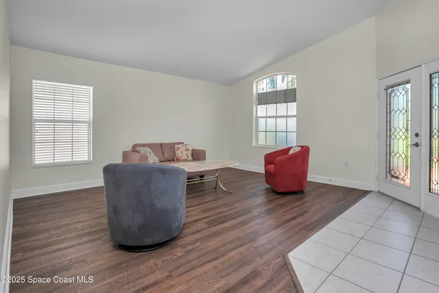 a view of a livingroom with wooden floor and a chandelier