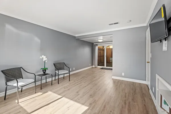 a furnished livingroom with windows and wooden floor