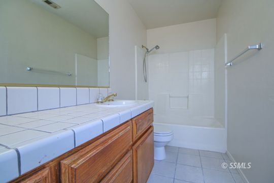 649 Regency Court Ridgecrest, CA 93555 - Photo 23 of 31 a bathroom with a granite countertop sink a toilet and shower