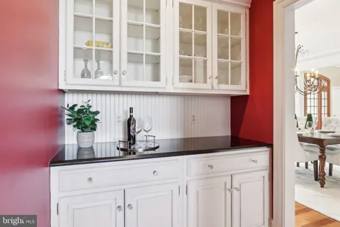 a view of a hallway with wooden floor and a chandelier