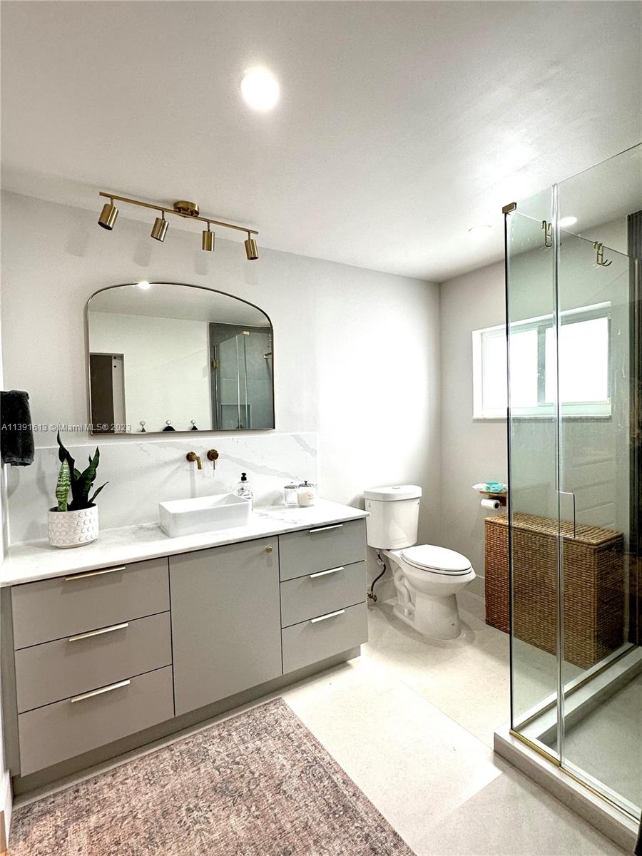 8949 Southwest 9th Street Boca Raton, FL 33433 - Photo 23 of 46 a bathroom with a toilet sink and mirror
