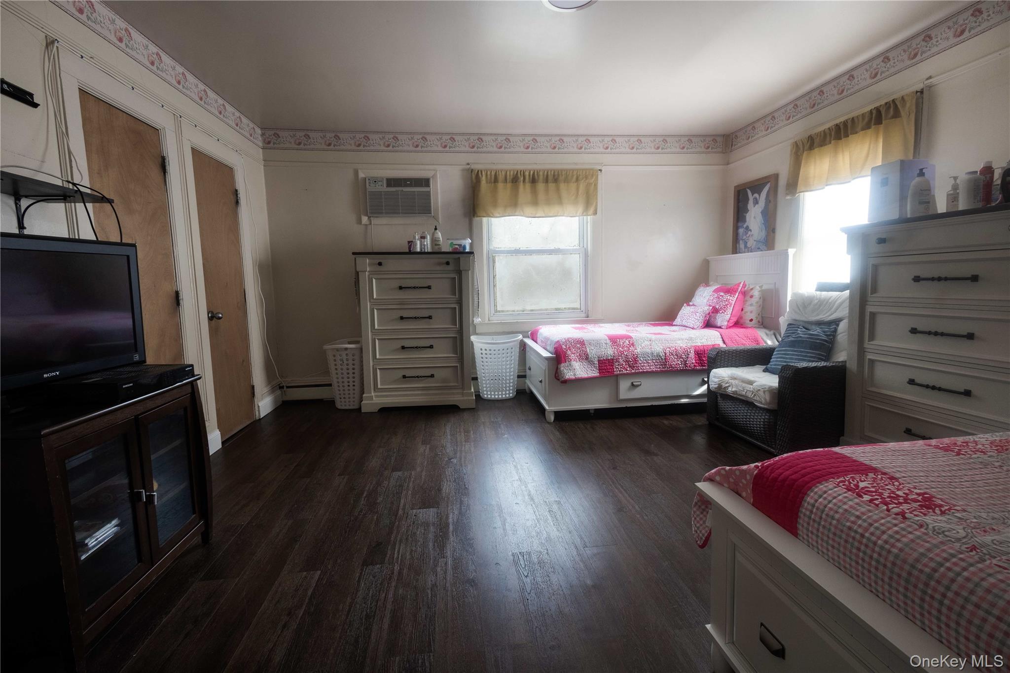 2 Old Cedar Swamp Road Jericho, NY 11753 - Photo 12 of 30 a bedroom with a bed and wooden floor