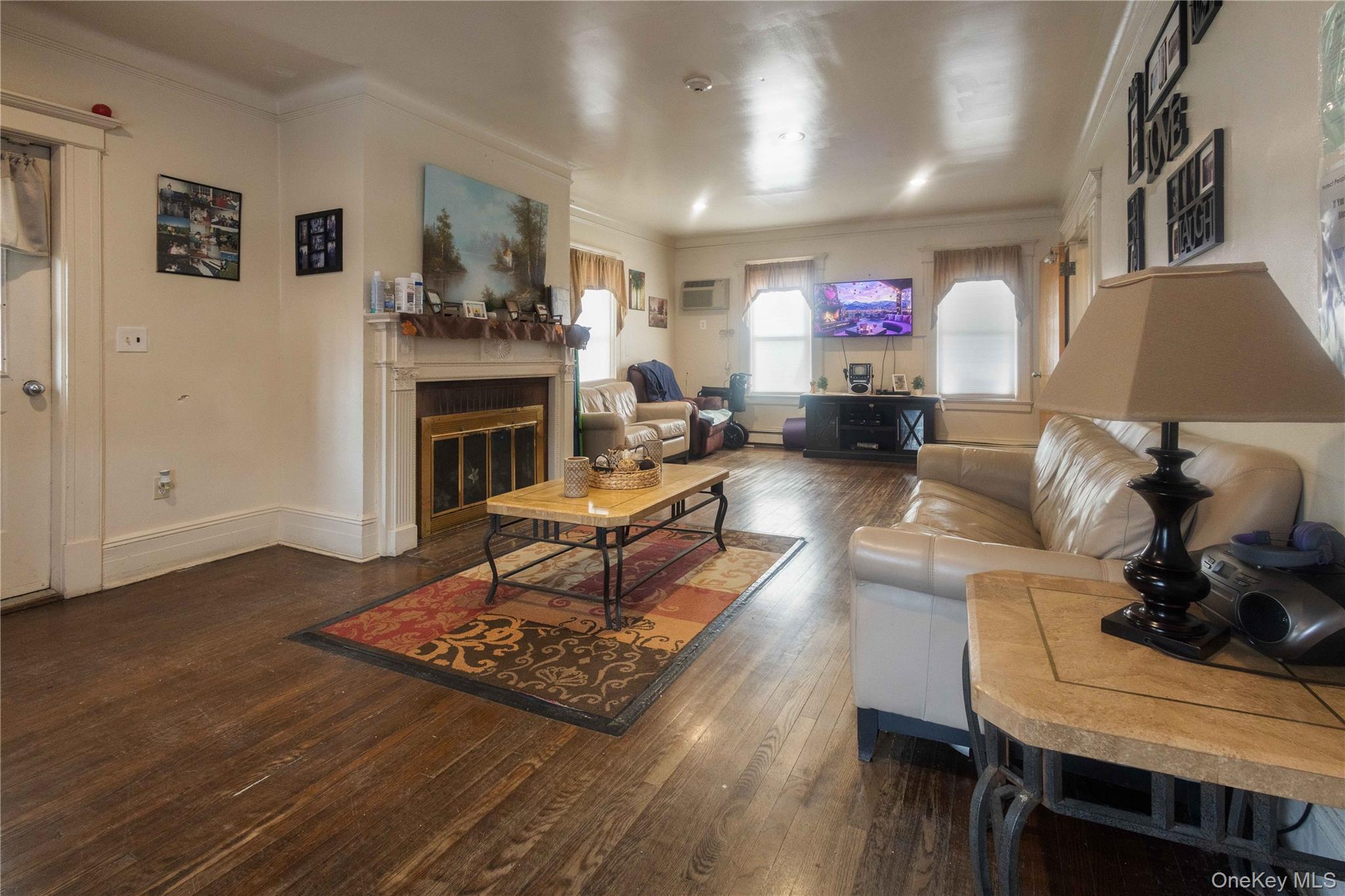 2 Old Cedar Swamp Road Jericho, NY 11753 - Photo 4 of 30 a living room with furniture a fireplace and a flat screen tv