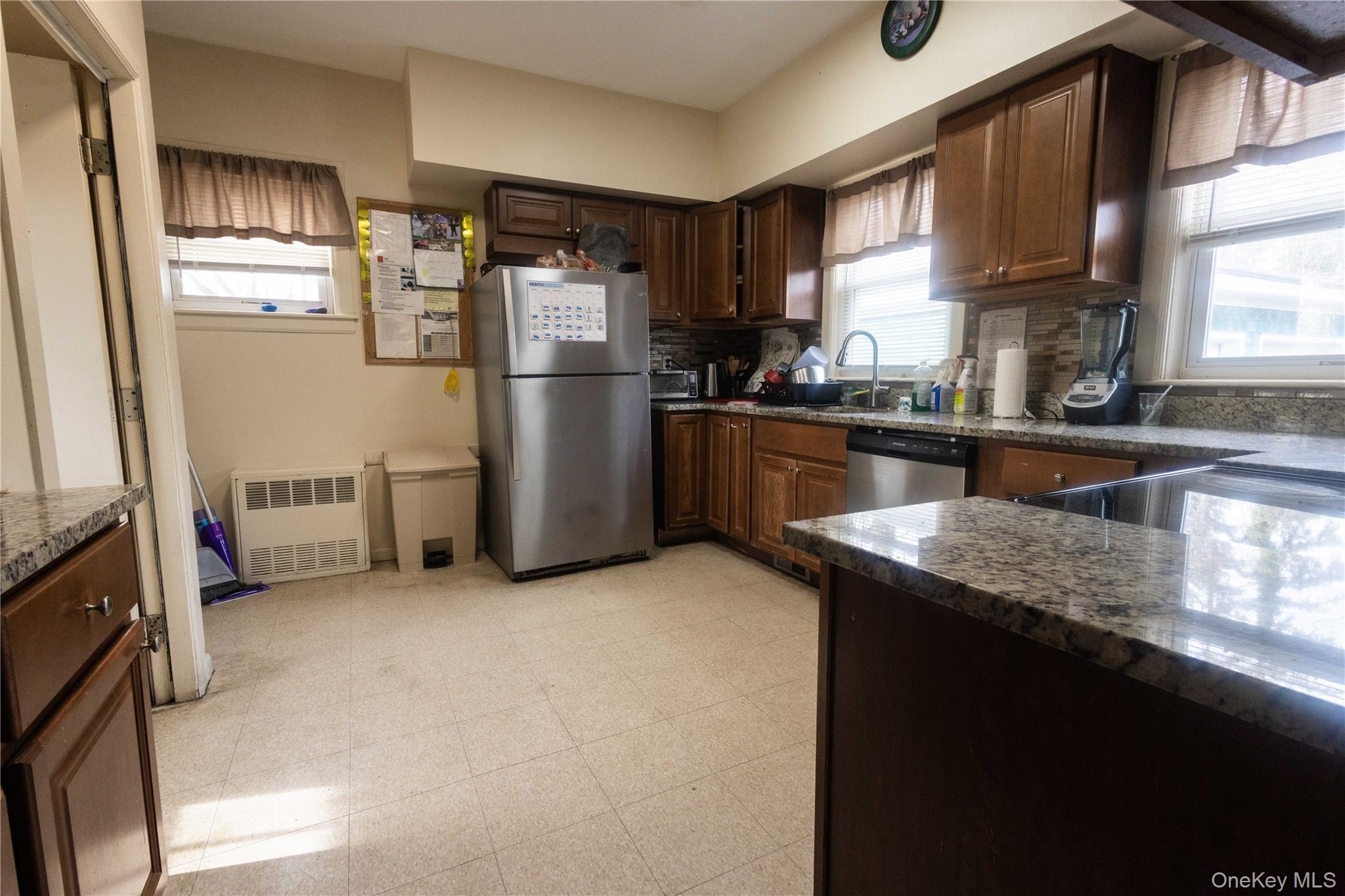 2 Old Cedar Swamp Road Jericho, NY 11753 - Photo 9 of 30 a kitchen with stainless steel appliances granite countertop a refrigerator a sink a stove and a microwave