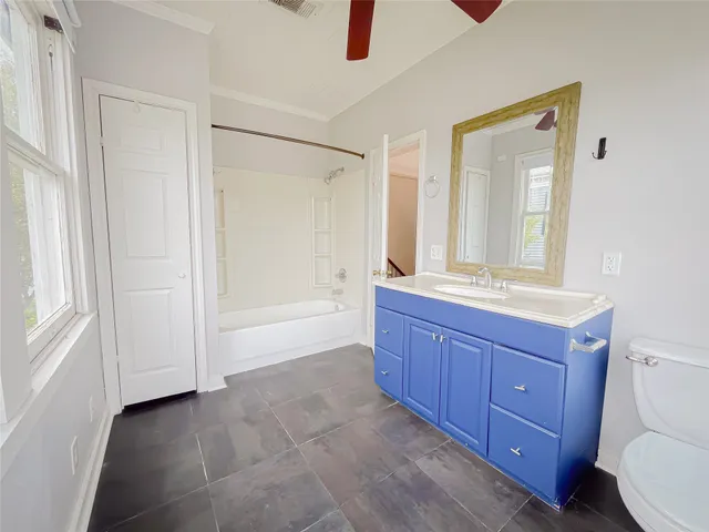 a bathroom with a granite countertop sink a mirror and a bathtub