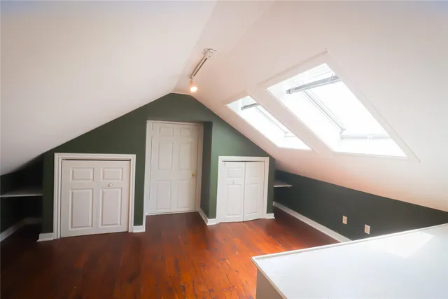 a view of an empty room with closet and a window