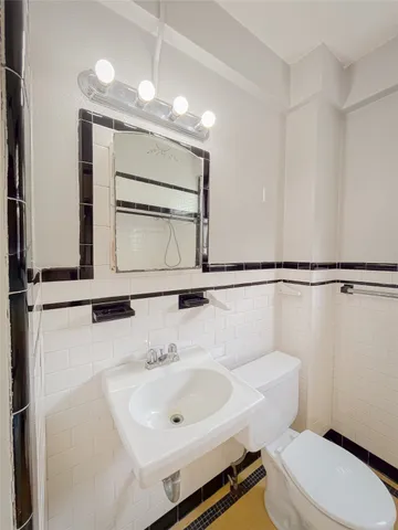 a bathroom with a sink a toilet and mirror