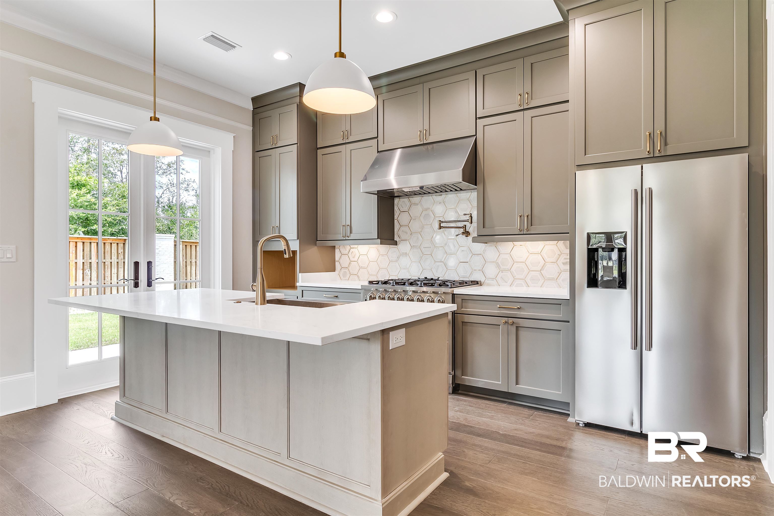 829 Inlet Circle Gulf Shores, AL 36542 - Photo 3 of 31 Kitchen featuring a kitchen island with sink, appliances with stainless steel finishes, plenty of natural light, and light hardwood / wood-style floors