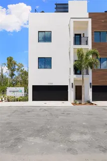 a view of a house with a yard and potted plants