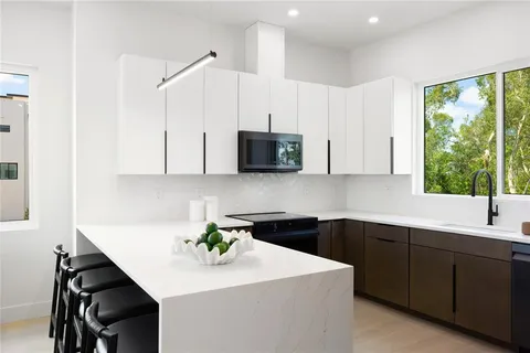 a kitchen with a sink a microwave and cabinets