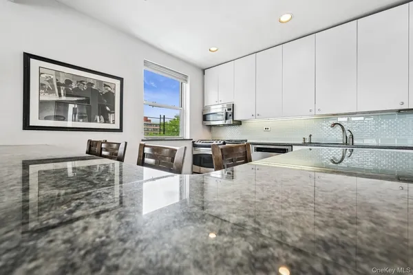 a large kitchen with stainless steel appliances granite countertop a sink stove and cabinets
