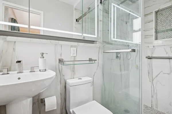 a bathroom with a sink a toilet and shower