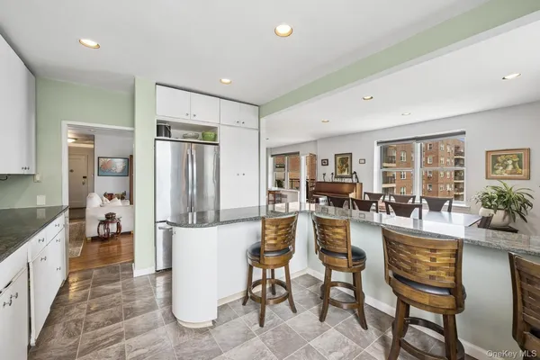 a view of a dining room kitchen and livingroom with furniture wooden floor a chandelier