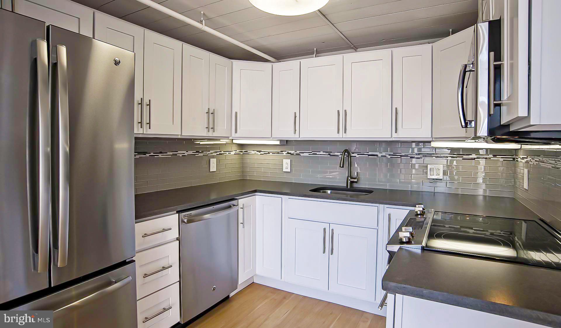 2300 Walnut Street, Unit 515 Philadelphia, PA 19103 - Photo 22 of 27 a kitchen with stainless steel appliances granite countertop a sink stove and cabinets