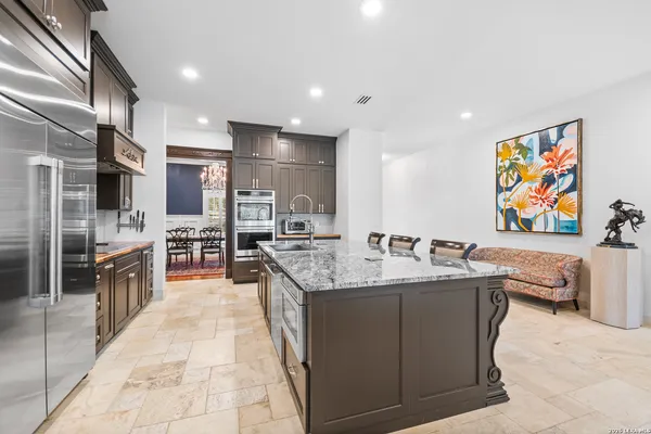 a kitchen with stainless steel appliances granite countertop a sink a stove and a refrigerator