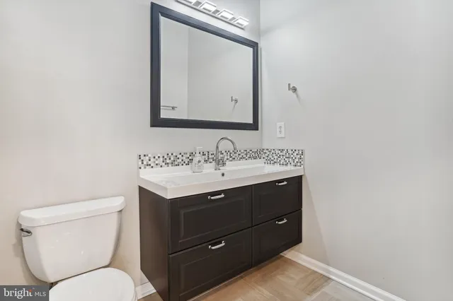a bathroom with a toilet sink and mirror