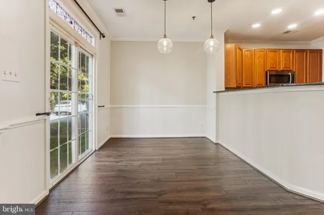 a view of a kitchen with wooden floor and windows