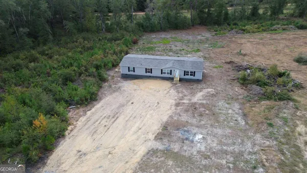 a view of a small house with a yard
