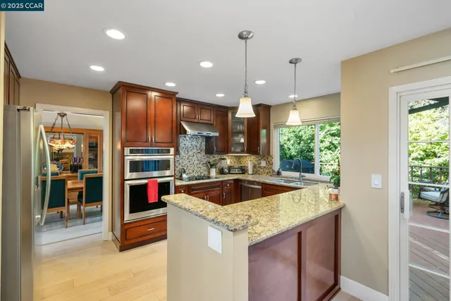 a kitchen with granite countertop stainless steel appliances a refrigerator a sink and cabinets