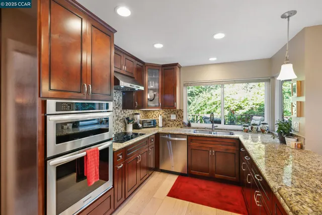 a kitchen with stainless steel appliances granite countertop a refrigerator and a stove