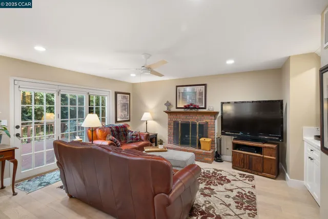 a living room with furniture fireplace and a large window