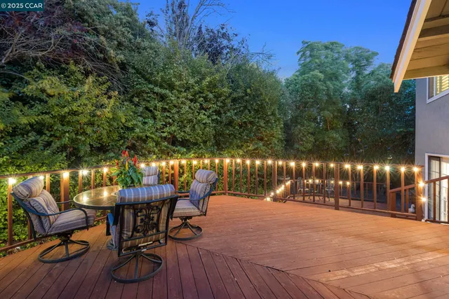 a view of a deck with two chairs and wooden fence