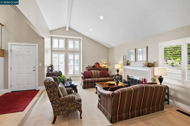 a living room with furniture a ceiling fan and a window