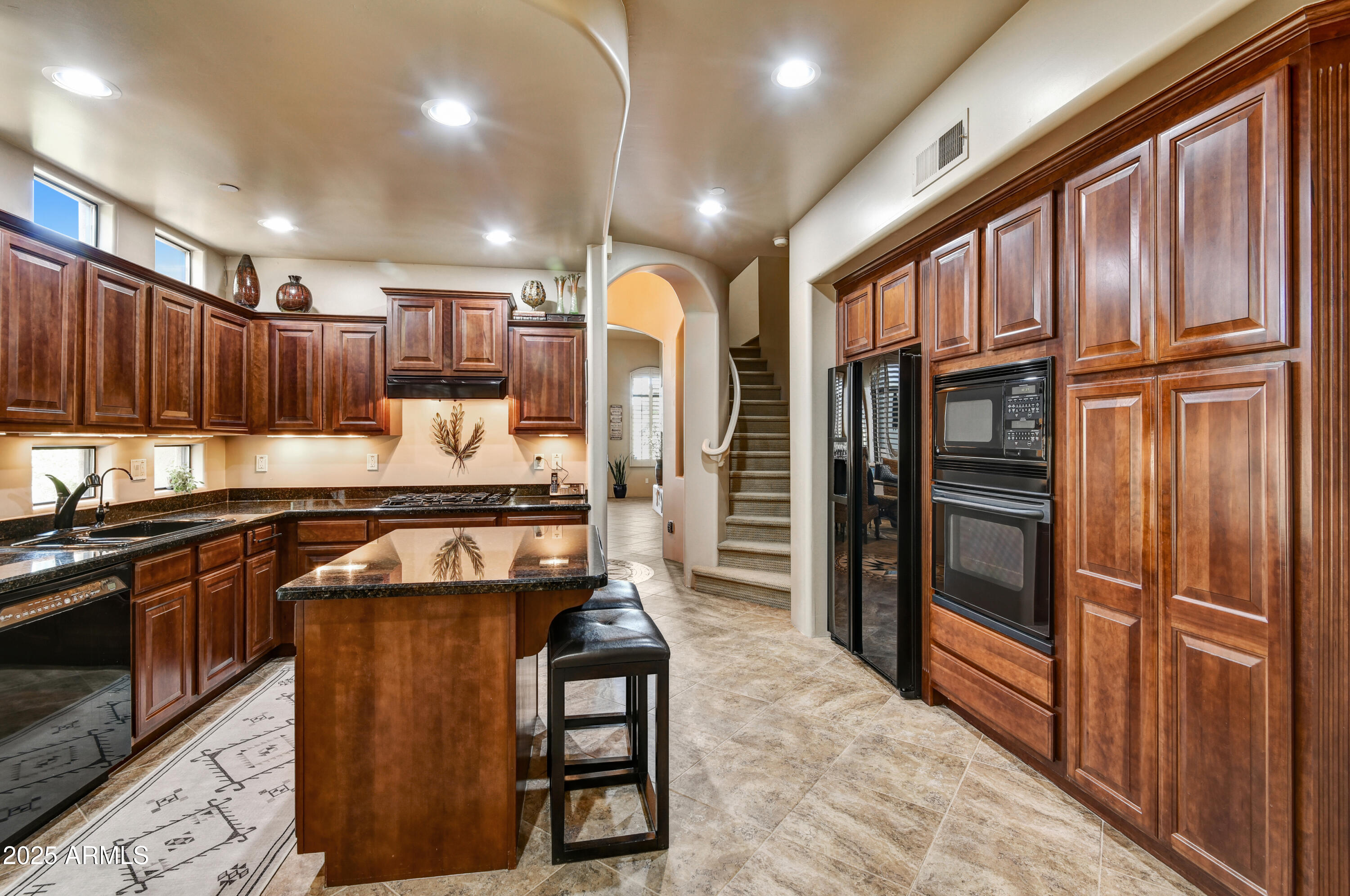 7199 East Ridgeview Place, Unit 100 Carefree, AZ 85377 - Photo 2 of 25 a kitchen with granite countertop stainless steel appliances and wooden cabinets