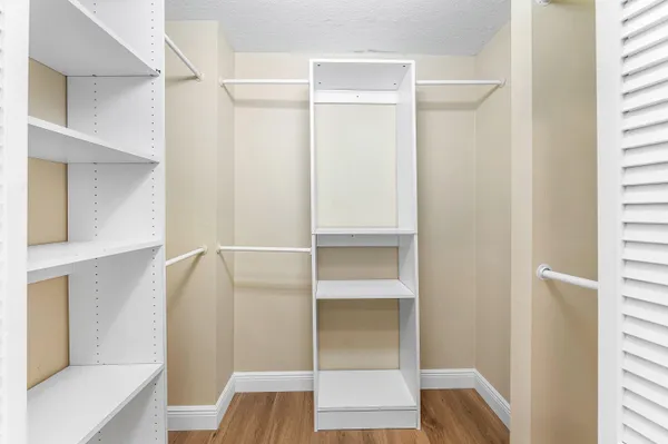 a view of walk in closet with empty racks
