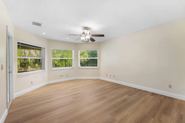 a view of an empty room with a window and wooden floor