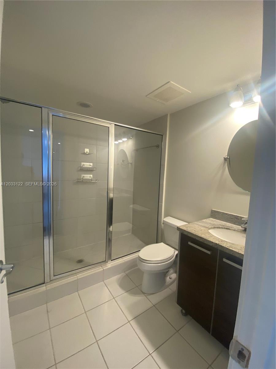 185 Southwest 7th Street, Unit 4206 Miami, FL 33130 - Photo 11 of 26 a bathroom with a granite countertop sink toilet and shower