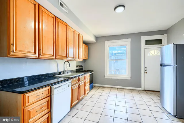 a kitchen with stainless steel appliances granite countertop a stove a sink and a refrigerator