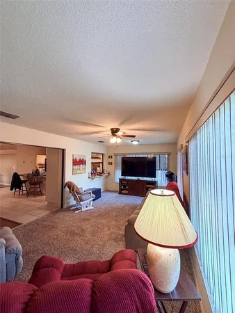 a living room with furniture a flat screen tv and white walls
