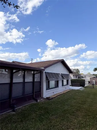 a view of a yard in front of a house with a large tree