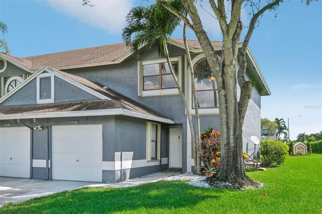 5894 Northpointe Lane Boynton Beach, FL 33437 - Photo 1 of 1 a view of a white house with a big yard and large tree