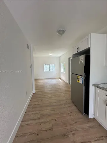 a view of a refrigerator in kitchen and wooden floor