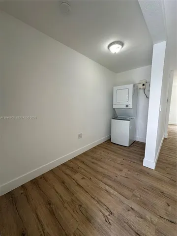 a view of empty room with wooden floor and sink