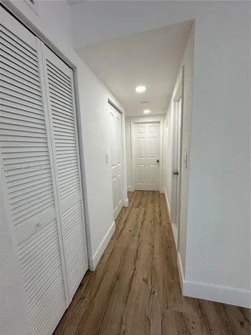a view of a hallway with wooden floor