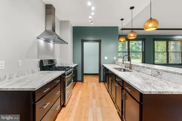 a large kitchen with kitchen island a sink and a wooden floors