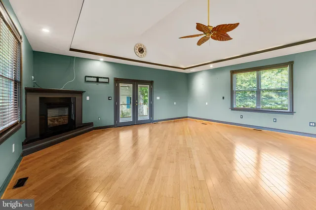 a view of an empty room with a fireplace and a window