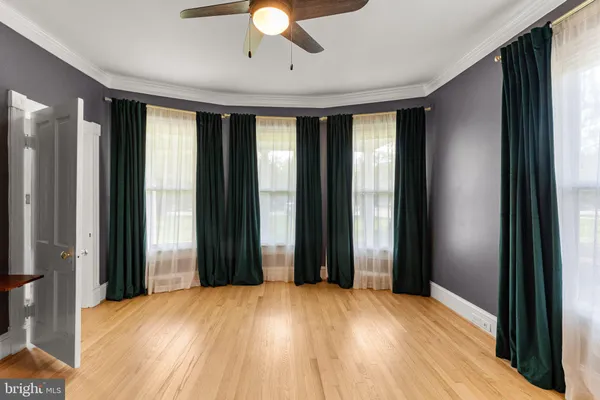 a view of empty room with window and ceiling fan