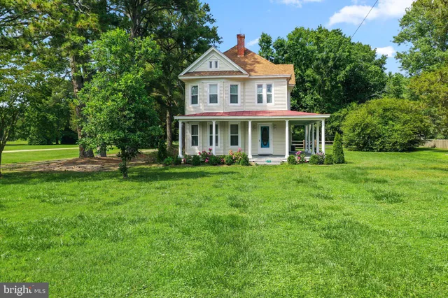 a front view of a house with a yard and trees