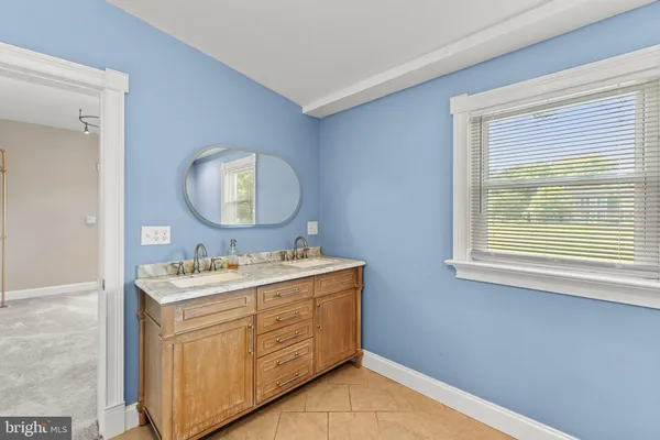a bathroom with a toilet sink vanity and mirror