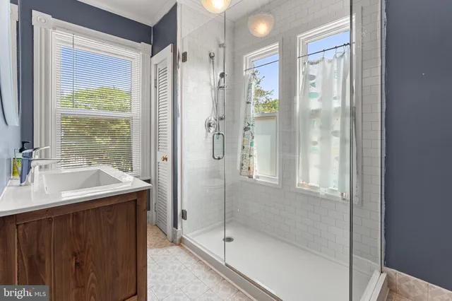 a bathroom with a shower sink and mirror