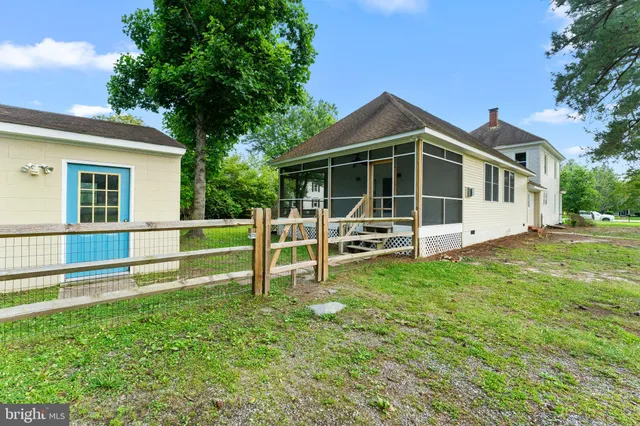 a view of a house with backyard and a tree