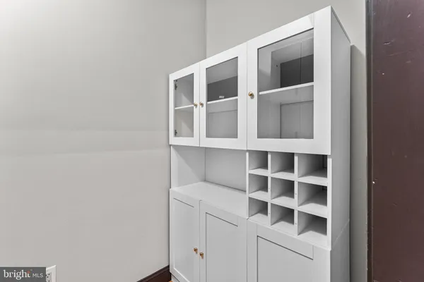 a view of a living room with kitchen furniture and a ceiling fan